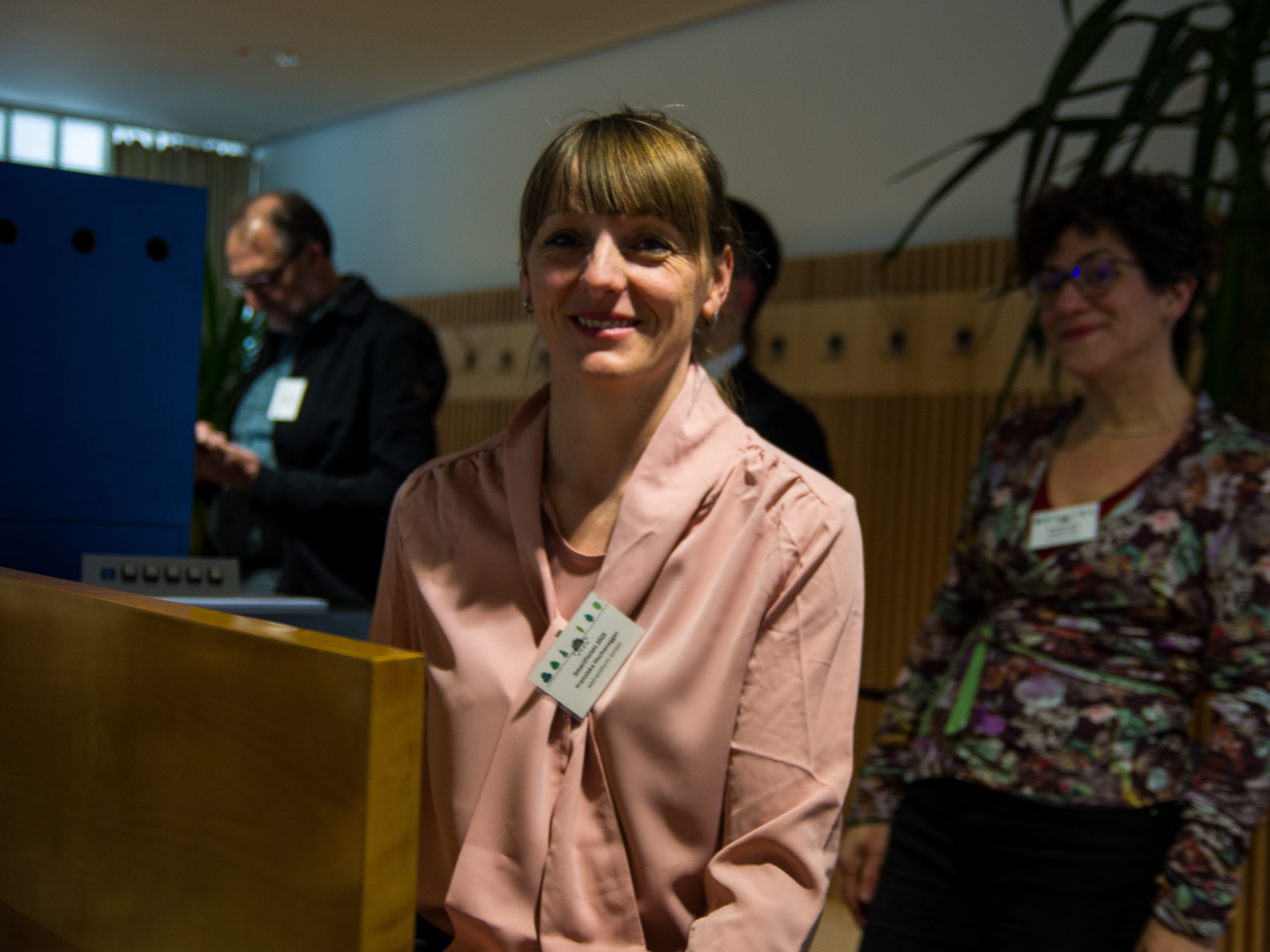 In the back of the lecture hall, SmartForest-organiser Franziska Hochenegger smiles at the camera.