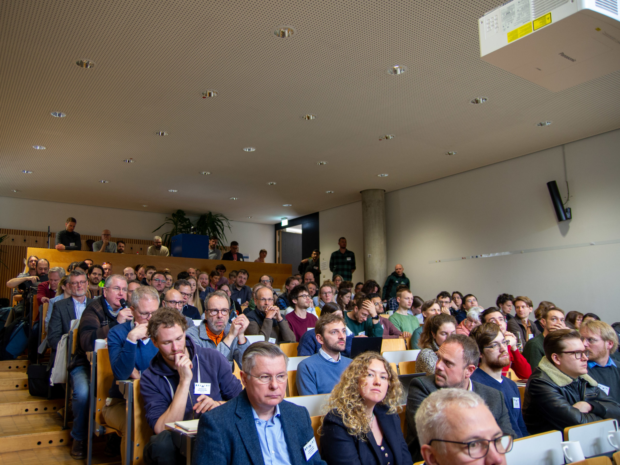A crowd shot of the big lecture hall at the Technical University of Munich during SmartForest 2025. The room is full, with virtually every seat occupied and a small group of people standing in the back.