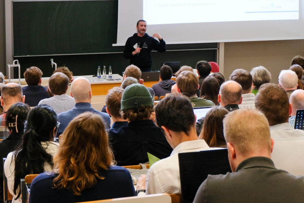A crowd of people listens diligently as Stefano Puliti of NIBIO presents his keynote