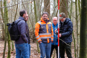 Participants of a SmartForest 2026 outdoor session have a chat in the woods as tree scanning technology is being demonstrated.