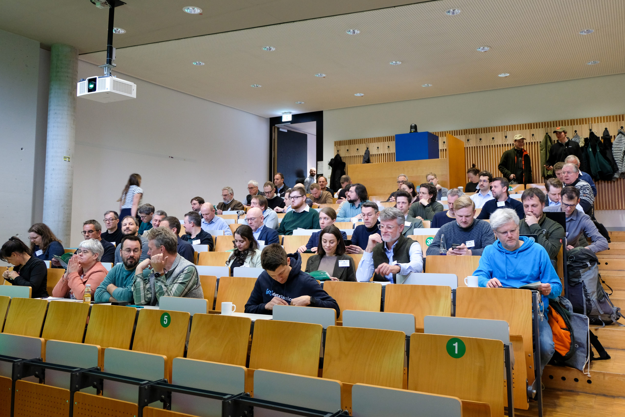 People examine their programme booklets in an auditorium at the SmartForest 2026 conference
