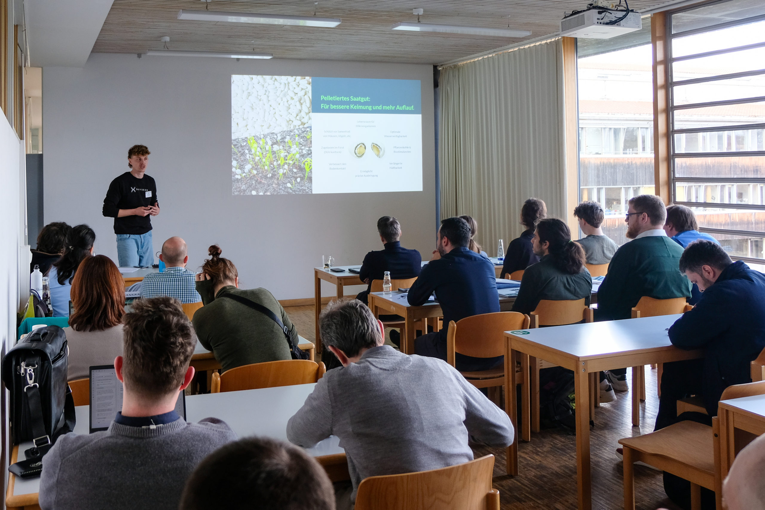 A classroom full of people pay attention as Leonard Sauter of Skyseed GmbH presents at SmartForest 2026