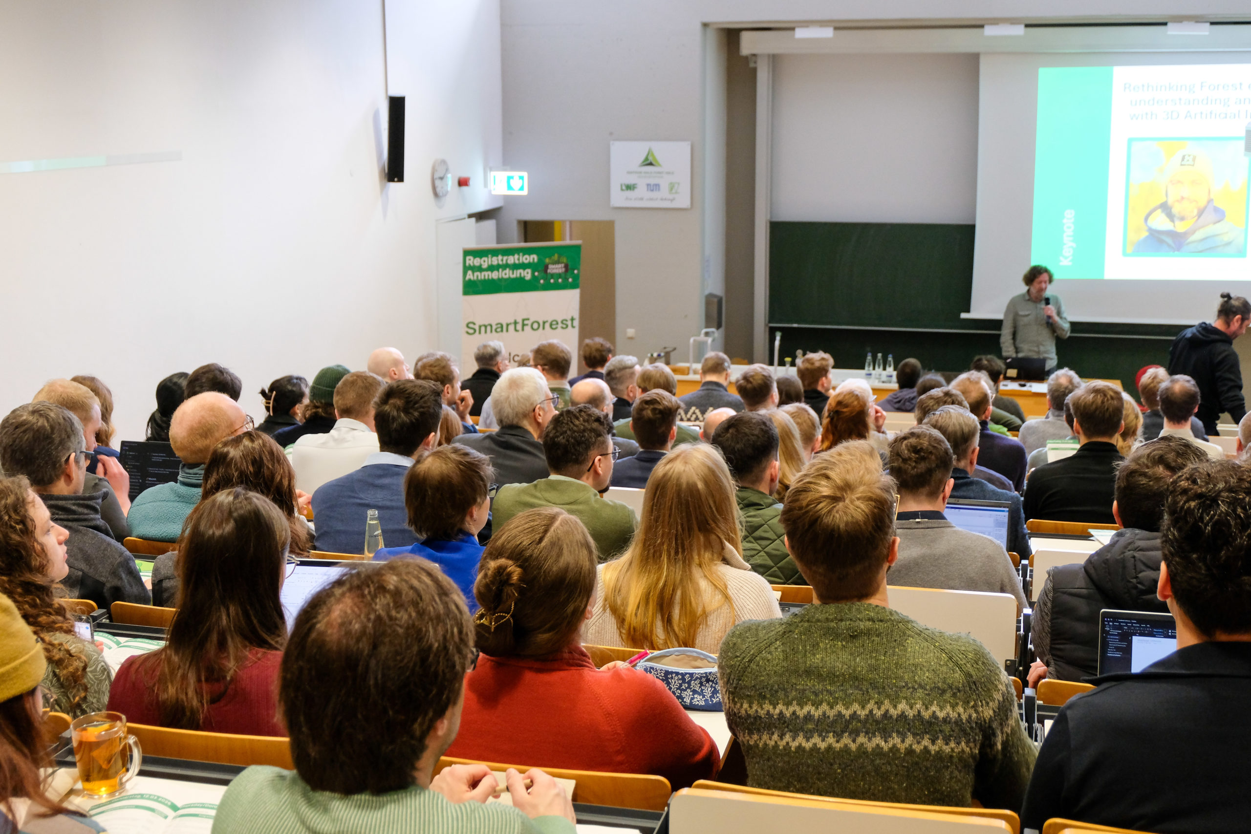 Shot from the back of the room at SmartForest 2026 as Dr. Werner Rammer introduces keynote speaker Stefano Puliti.